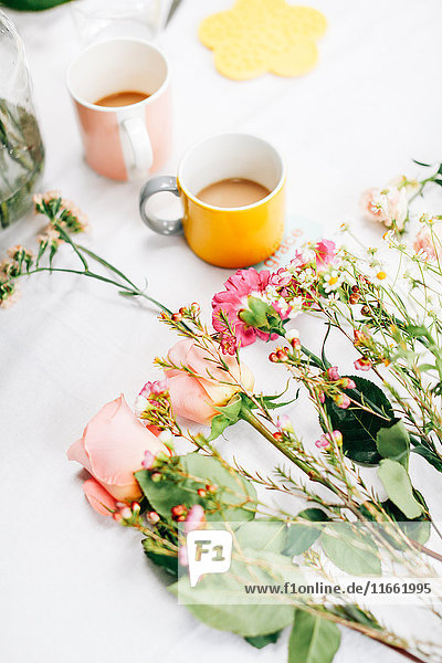 Tisch mit Schnittblumen und Kaffeetassen beim Blumenarrangement-Workshop