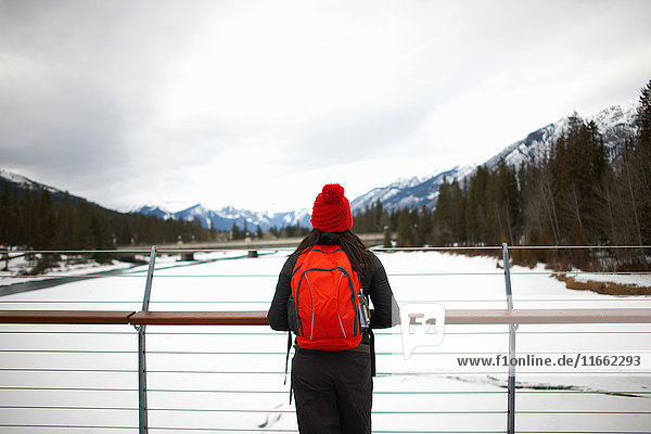 Hiker on bridge looking at snow capped mountains  Banff  Canada