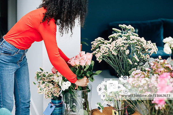 Floristinnen arrangieren Rosen in Vase für Ladenpräsentation