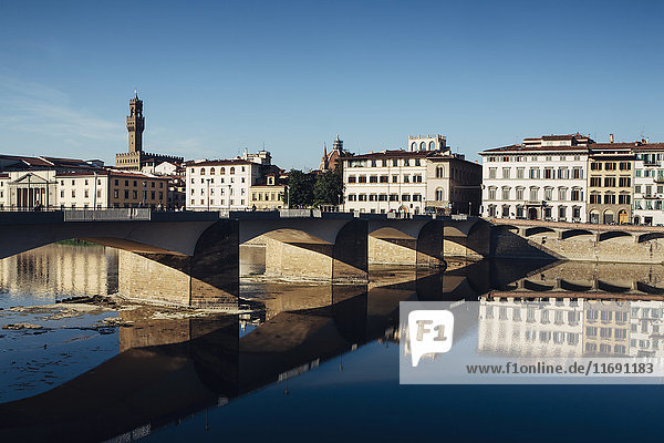 Die Ponte alle Grazie  historische Brücke über das flache  ruhige Wasser des Arno  mitten in Florenz.
