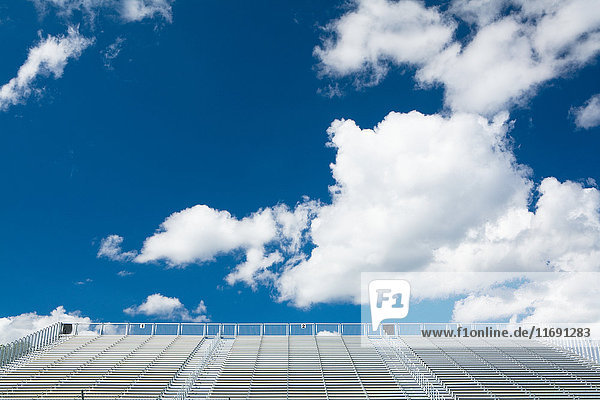 Blauer Himmel und Wolken über leeren Stadionplätzen