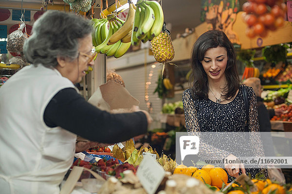 Woman shopping at greengrocer's in market