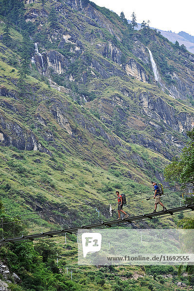 Trekker überqueren eine 60 Meter lange Hängebrücke nördlich von Tal  Bhulbhule  Nepal