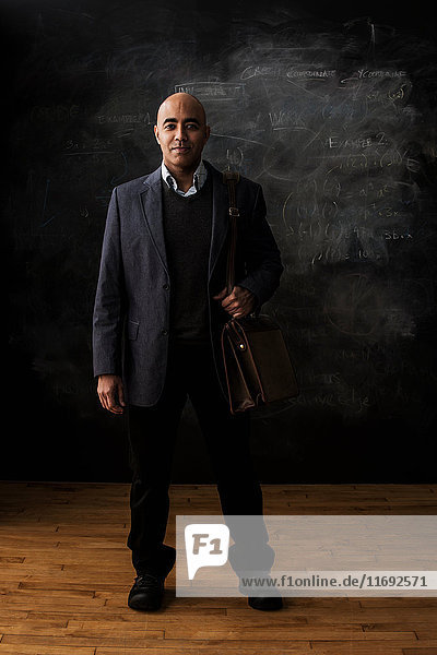 Businessman by blackboard with satchel