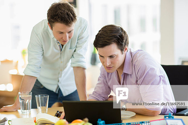 Junge Männer arbeiten am Laptop im Kreativbüro