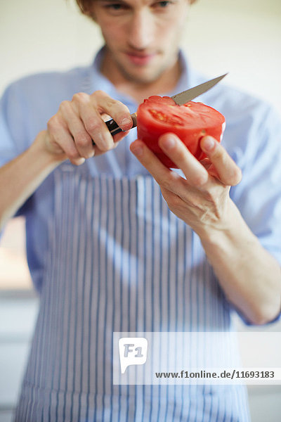 Close up of man slicing tomato