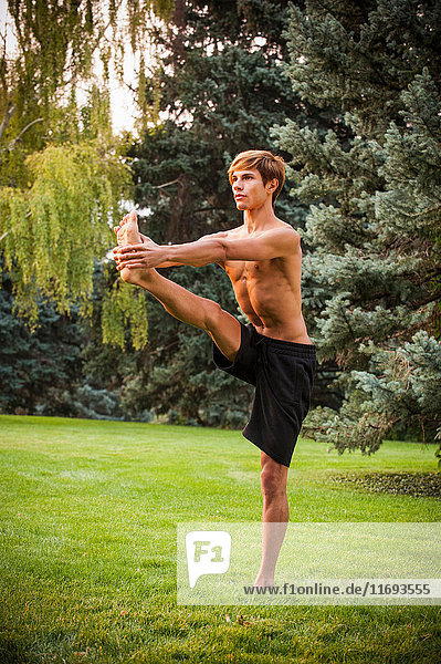 Man practicing yoga in park