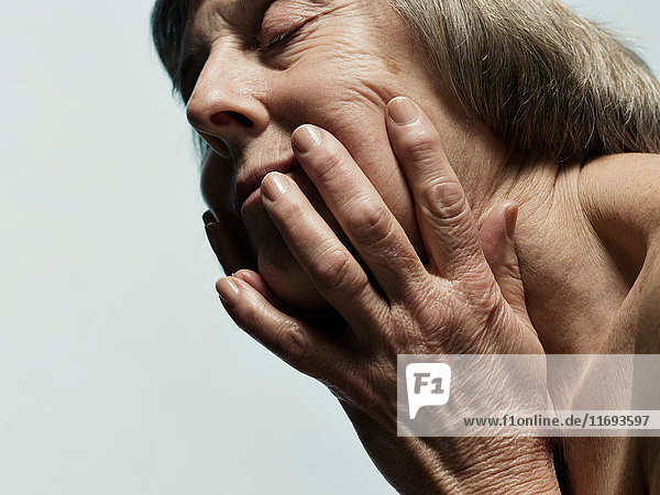 Older woman clutching her face