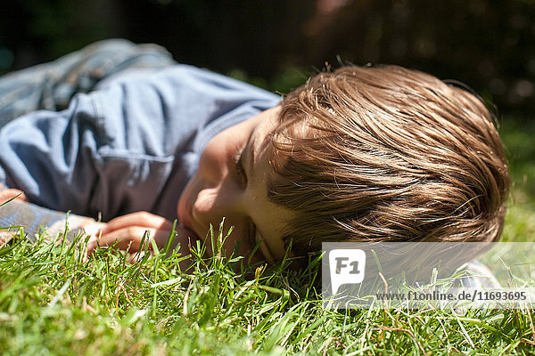 Auf Gras liegender Junge