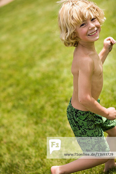 Lächelnder Junge spielt im Hinterhof