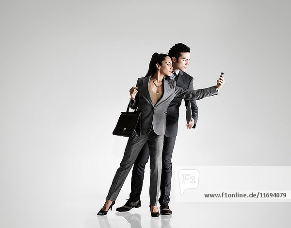 Business couple using cell phone