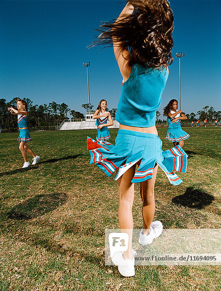 Cheerleader führen Tanzroutine auf dem Sportplatz auf