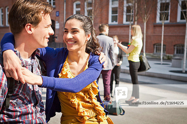 Couple hugging on city street