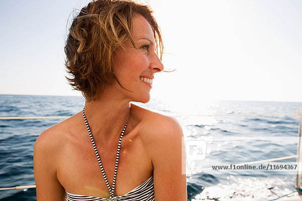 Lächelnde Frau im Bikini auf dem Boot