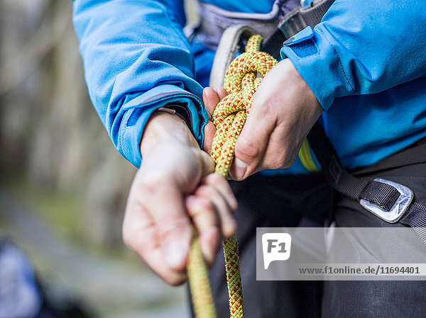 Rock climber tying rope