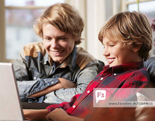 Teenager Junge und Bruder beobachten Laptop