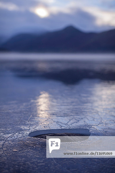 Loch in Eisschicht auf ländlichem See