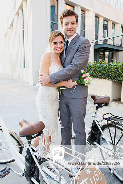 Porträt eines jungen frisch verheirateten Paares mit Fahrrädern