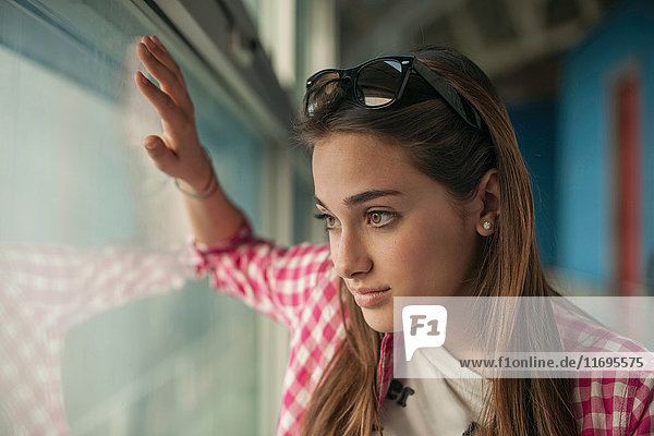 Teenage girl looking through window