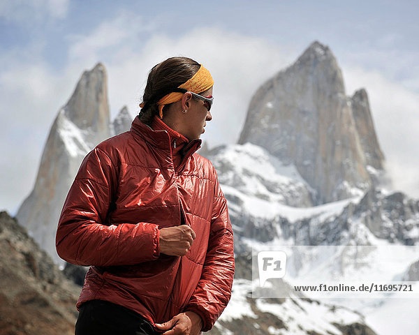 Woman zips her jacket in front of Monte Fitz Roy in Los Glaciares National Park  El Chalten  Argentina