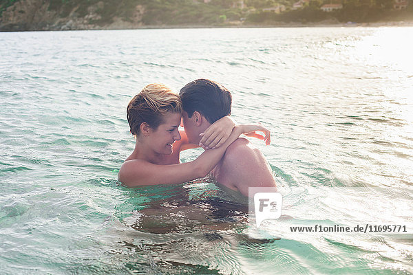 Lächelndes Paar umarmt sich im Wasser