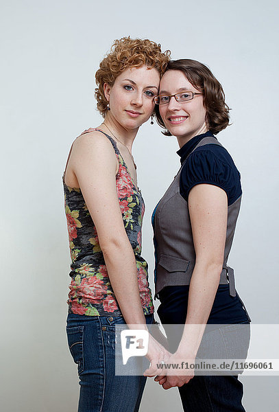 Porträt eines lesbischen Paares  das Händchen hält  Studioaufnahme