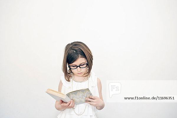 Mädchen mit Brille liest Buch