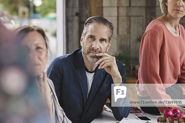Businessman looking at colleague giving presentation in portable office truck