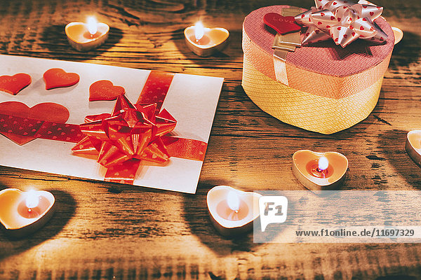 Valentine Kerzen brennen auf dem Tisch mit Geschenk-Box und Karte