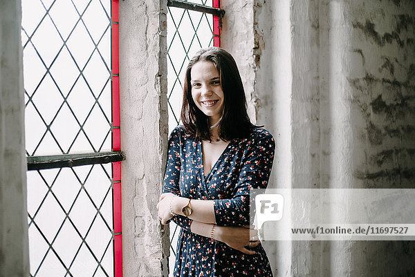 Portrait of smiling Caucasian woman standing near window