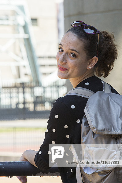 Portrait of smiling Caucasian teenage girl carrying backpack
