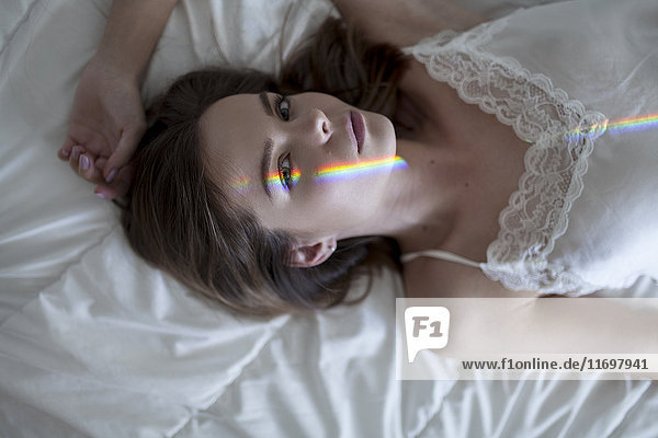 Caucasian woman laying on bed wearing nightgown