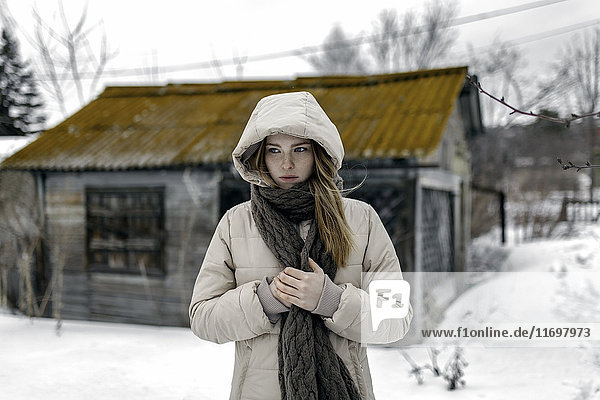 Kaukasische Frau mit Mantel und Schal im Winter