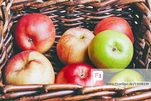 Korb mit Äpfeln auf Holztisch