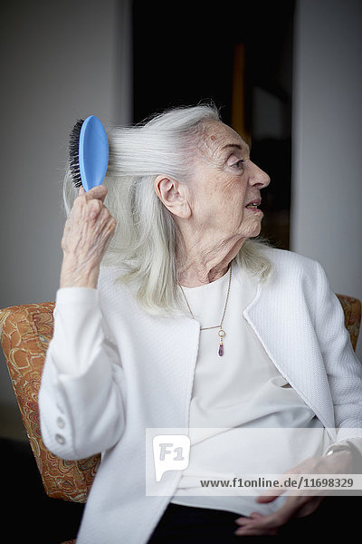 Older Caucasian woman brushing hair