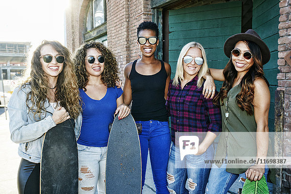 Frauen posieren mit Skateboards in der Stadt