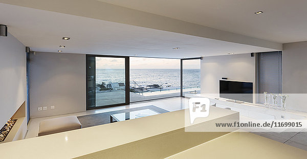 Modern  minimalist luxury living room with patio doors open to ocean view