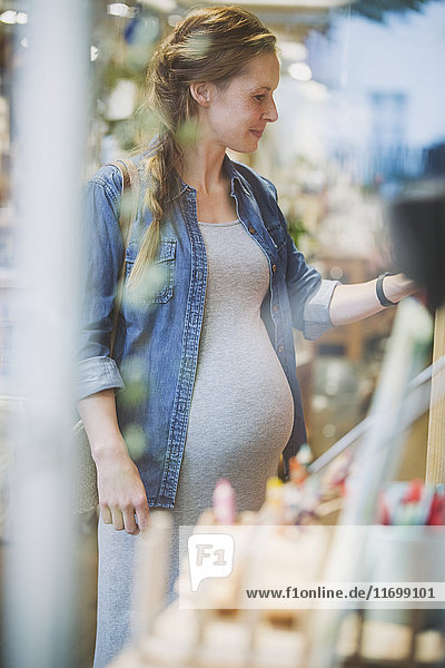 Schwangere Frau beim Einkaufen im Geschäft