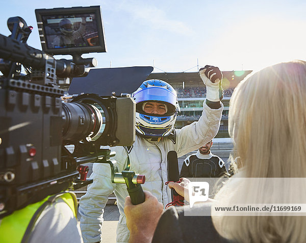 Nachrichtenreporter und Kameramann interviewt Formel 1 Fahrer jubelnd,  feiert Sieg