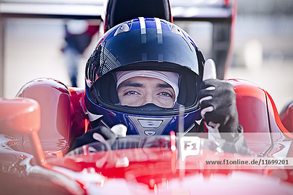 Portrait confident male formula one race car driver gesturing thumbs-up