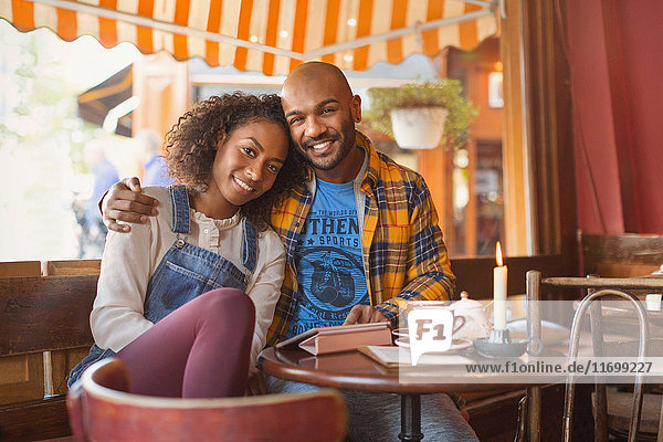 Portrait lächelndes  liebevolles junges Paar  das sich im Café umarmt.