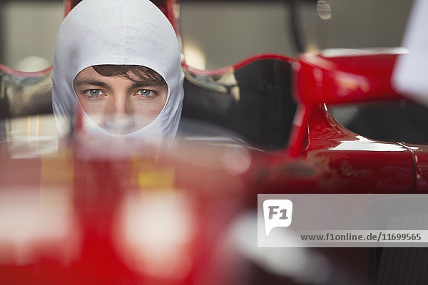 Close up portrait serious formula one race car driver wearing protective mask