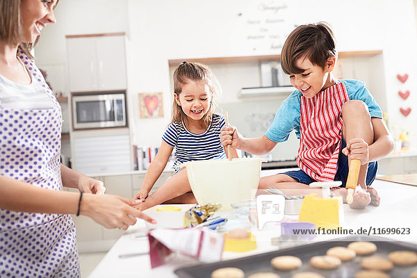 Mutter und Kinder backen Kekse in der Küche