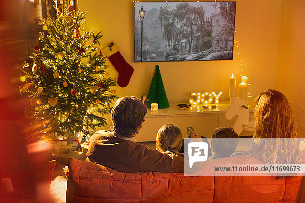 Familie beim Fernsehen im Weihnachtswohnzimmer