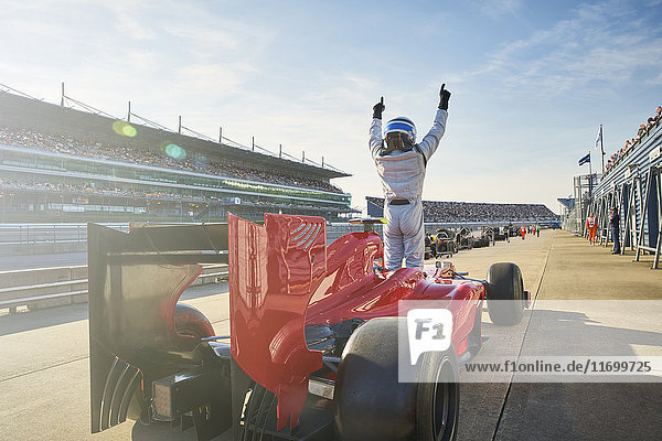 Formula one race car driver cheering on sports track  celebrating victory