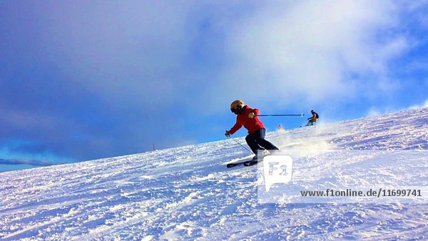 Skier on Ski Slope with Swirling Snow at Feet