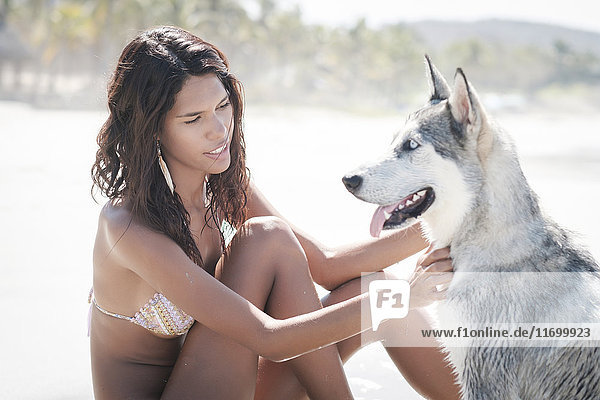 Mexiko  Riviera Nayarit Strand  junge Frau sitzend mit Husky Hund