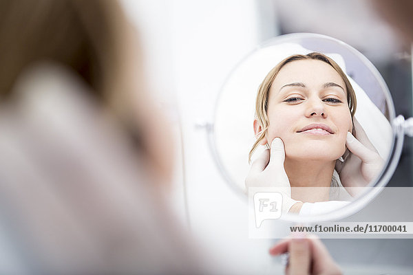 Aesthetic surgery  woman looking in mirror