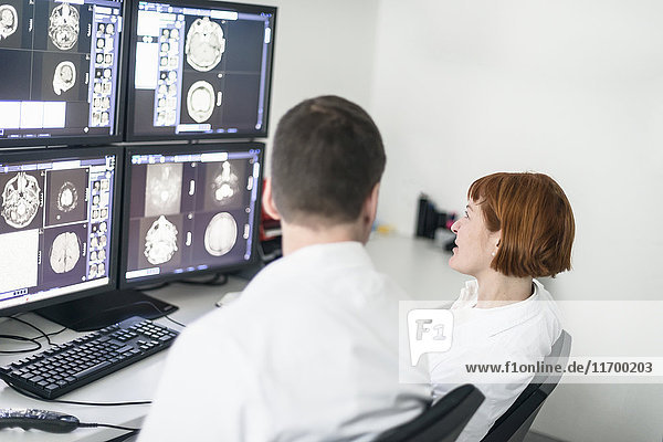 Zwei Ärzte diskutieren über Röntgenbilder am Computerbildschirm