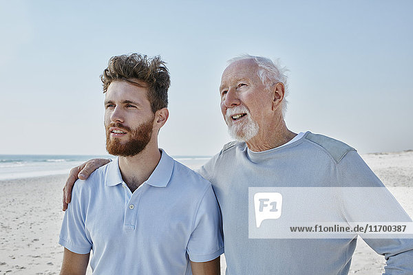 Senior Mann mit erwachsenem Sohn am Strand